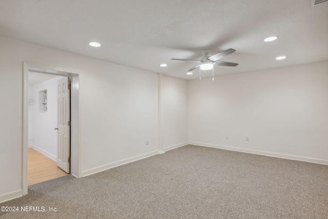 spare room with ceiling fan and light colored carpet