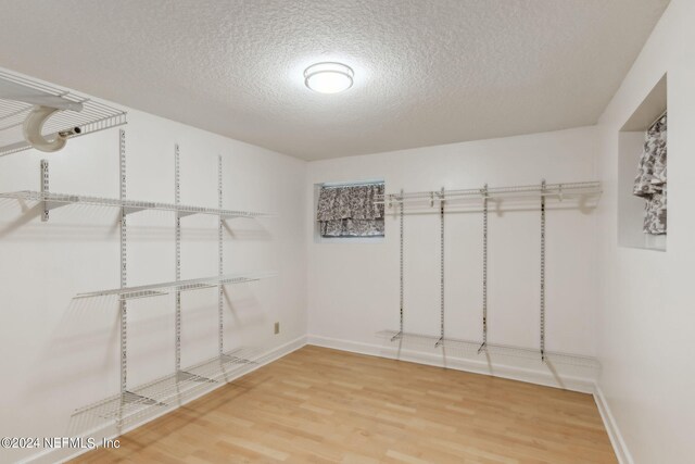 walk in closet with hardwood / wood-style flooring