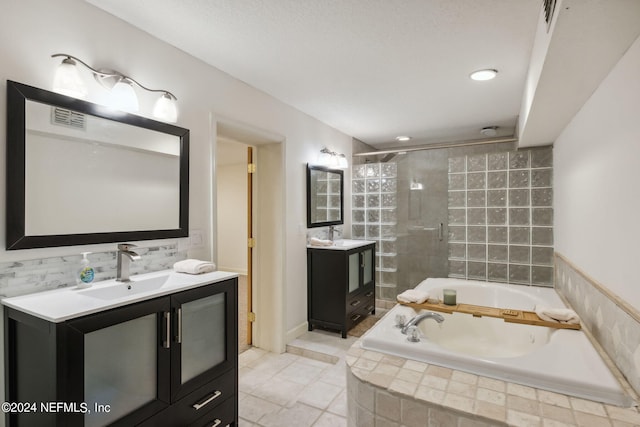 bathroom featuring a textured ceiling, vanity, and plus walk in shower