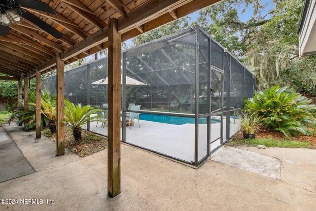 view of swimming pool featuring a patio and a lanai