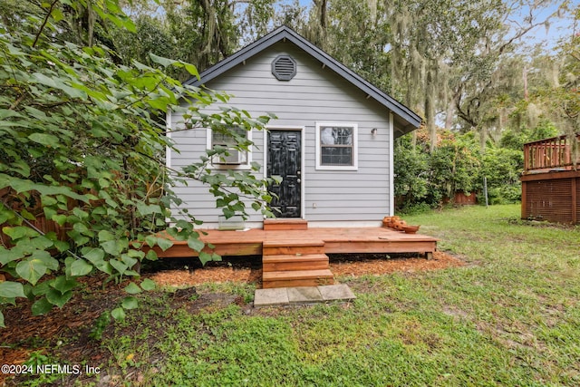 rear view of property featuring a yard and a deck