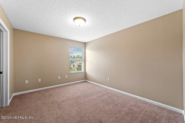 unfurnished room featuring carpet and a textured ceiling