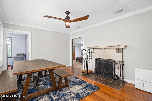 dining area featuring ceiling fan, ornamental molding, dark hardwood / wood-style flooring, and a fireplace