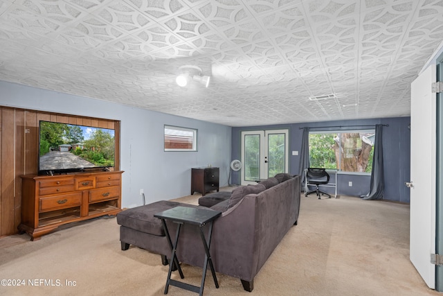 living room with french doors, a healthy amount of sunlight, and carpet flooring