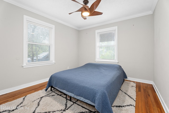 bedroom featuring hardwood / wood-style floors, ceiling fan, and crown molding