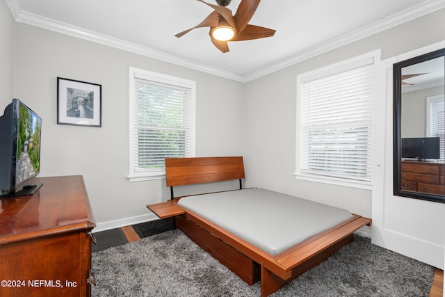 bedroom featuring ceiling fan, ornamental molding, hardwood / wood-style floors, and multiple windows