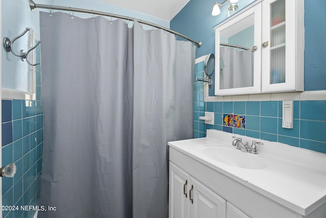 bathroom with vanity, tasteful backsplash, a shower with curtain, and tile walls