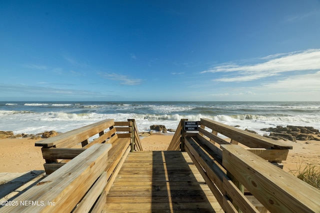 view of community with a beach view and a water view