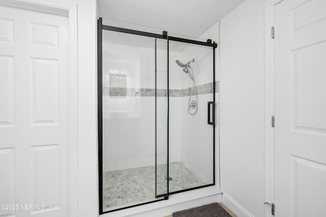 bathroom featuring a textured ceiling and an enclosed shower