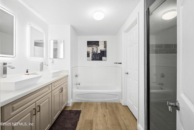 bathroom featuring hardwood / wood-style flooring, vanity, a textured ceiling, and independent shower and bath