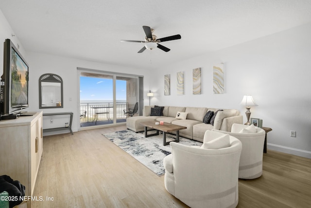 living room featuring ceiling fan and light hardwood / wood-style floors