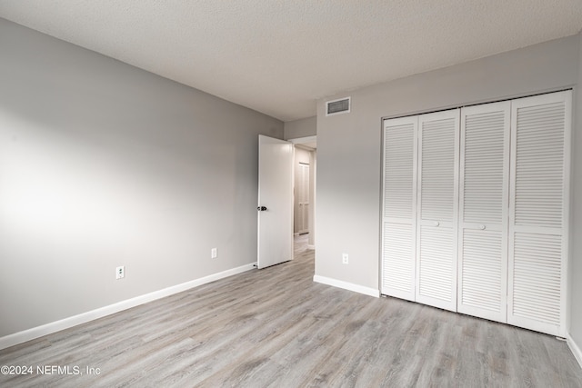 9360 Craven Rd Unit 504, Jacksonville, FL 32257 - unfurnished bedroom featuring a closet, a textured ceiling, visible vents, baseboards, and wood finished floors