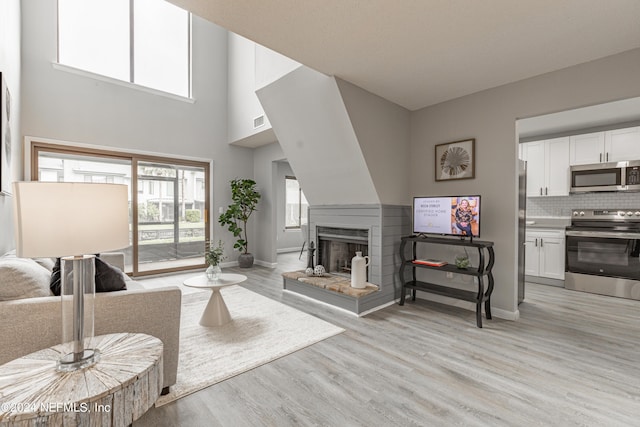 9360 Craven Rd Unit 504, Jacksonville, FL 32257 - living area featuring baseboards, a multi sided fireplace, visible vents, and light wood-style flooring
