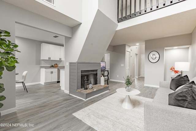 9360 Craven Rd Unit 504, Jacksonville, FL 32257 - living room featuring baseboards, a multi sided fireplace, a towering ceiling, and light wood finished floors