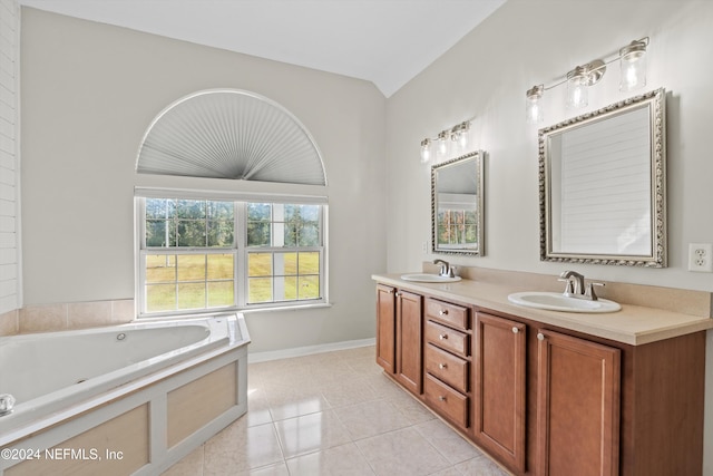 bathroom with vanity, tile patterned floors, a bath, and vaulted ceiling