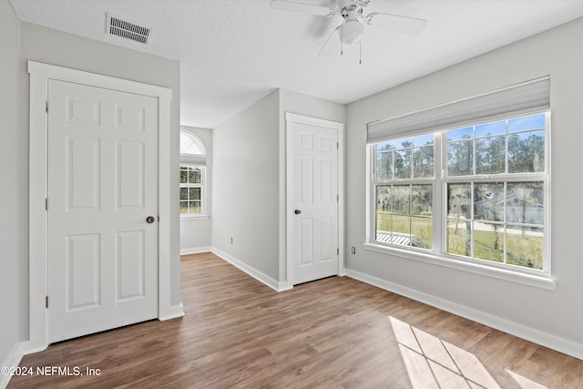 spare room with ceiling fan, a textured ceiling, and hardwood / wood-style floors