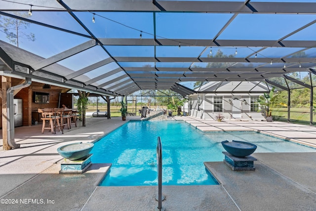 view of pool with a patio area, glass enclosure, and a bar