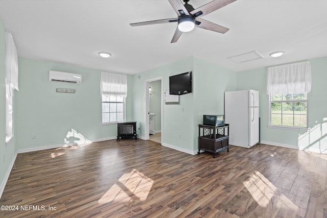 interior space with ceiling fan, a healthy amount of sunlight, dark hardwood / wood-style flooring, and a wall mounted air conditioner