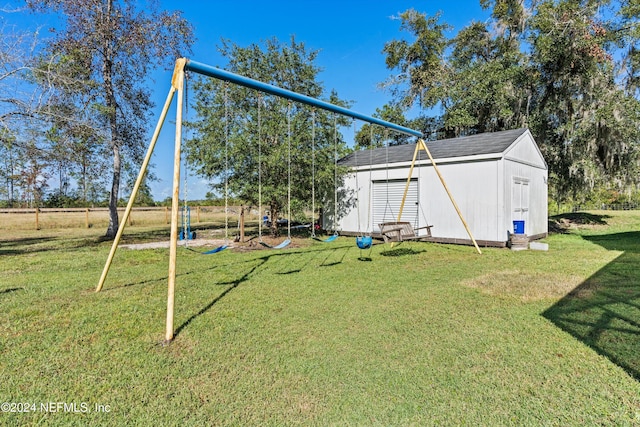 view of yard with a storage shed and a playground