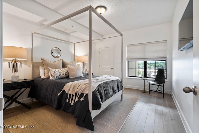 bedroom with hardwood / wood-style floors and a textured ceiling