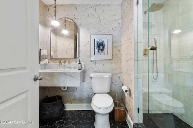 bathroom featuring tile patterned flooring, toilet, and a shower with door