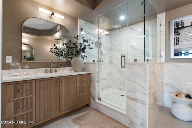 bathroom featuring vanity, tile walls, an enclosed shower, and tile patterned floors