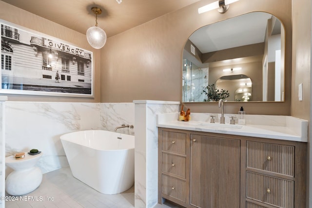 bathroom with a tub to relax in, vanity, and tile walls