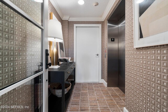 hallway featuring ornamental molding and elevator