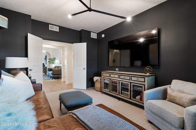 living room with a textured ceiling and light hardwood / wood-style floors