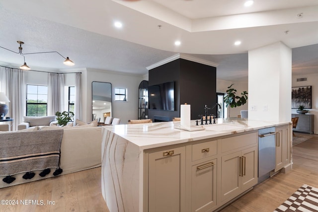 kitchen with crown molding, sink, light stone countertops, and light hardwood / wood-style floors