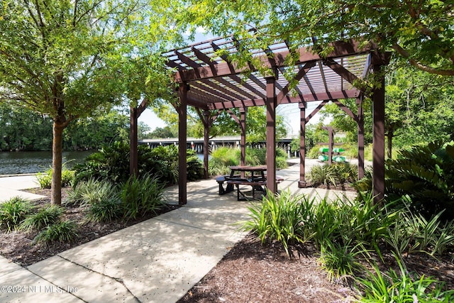 surrounding community featuring a patio area, a pergola, and a water view