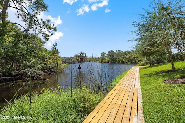 view of dock featuring a water view and a lawn