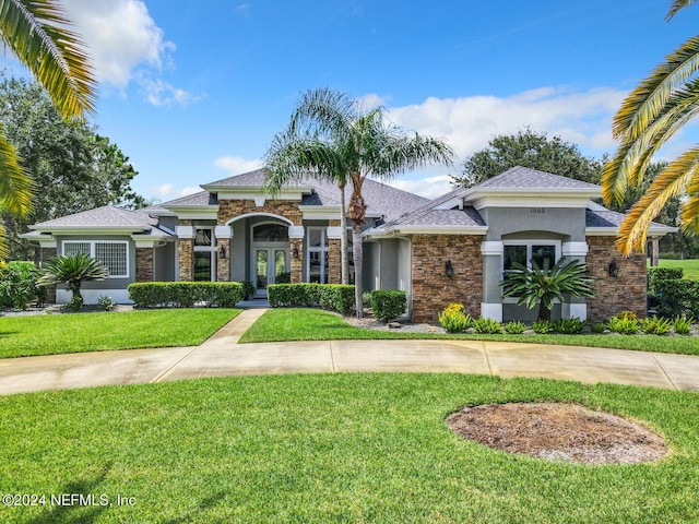 view of front of property featuring stucco siding, french doors, and a front yard