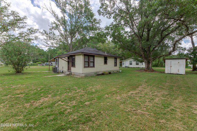 view of yard with central AC unit and a shed