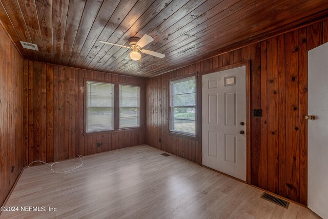 entrance foyer featuring ceiling fan, hardwood / wood-style floors, and wooden walls