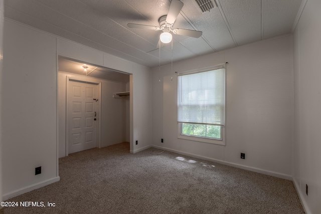 carpeted spare room featuring ceiling fan and a textured ceiling