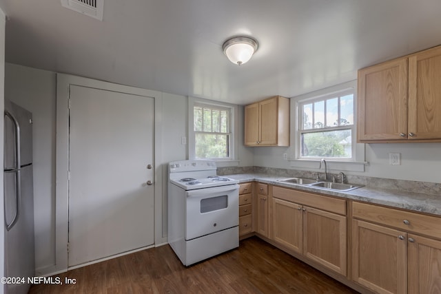 kitchen with plenty of natural light, stainless steel refrigerator, white range with electric stovetop, and sink