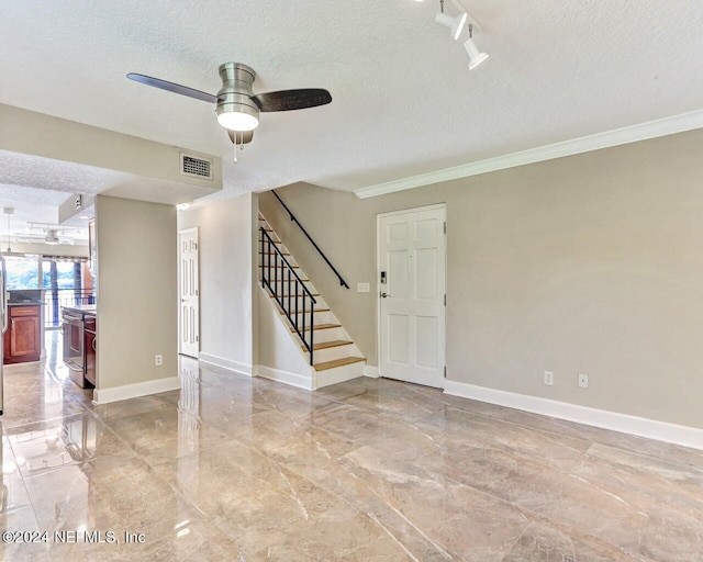 empty room featuring ornamental molding, track lighting, a textured ceiling, and ceiling fan