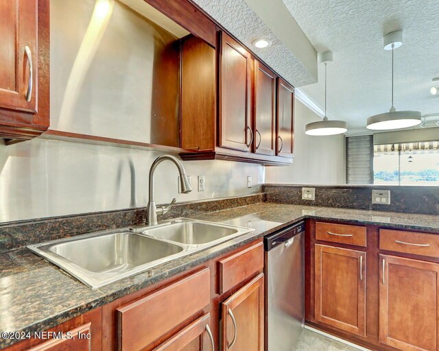 kitchen featuring hanging light fixtures, sink, stainless steel dishwasher, dark stone counters, and a textured ceiling