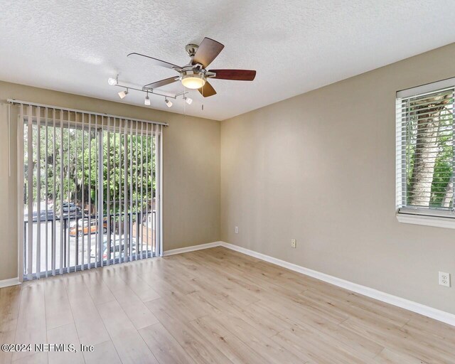 empty room featuring ceiling fan, light hardwood / wood-style floors, and a textured ceiling