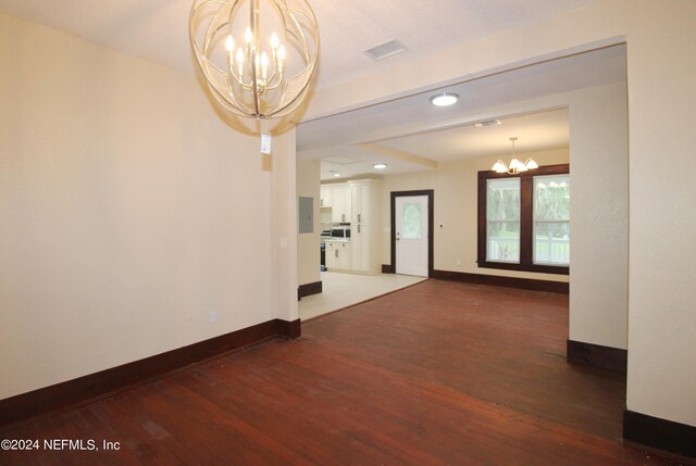 unfurnished room with an inviting chandelier and hardwood / wood-style flooring