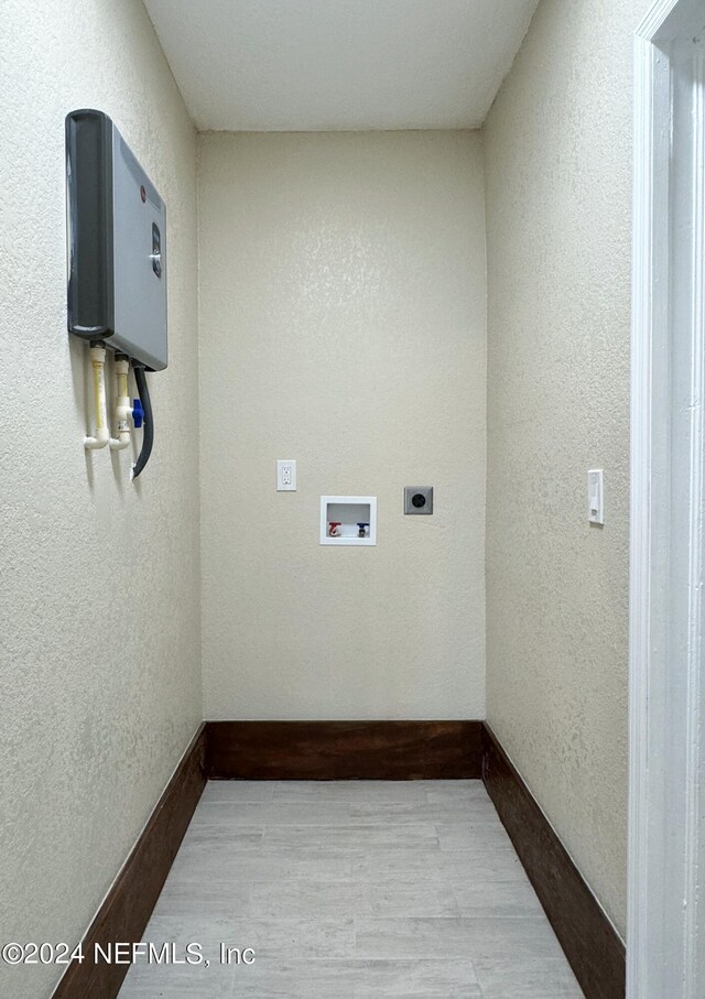 clothes washing area with washer hookup, hookup for an electric dryer, and light hardwood / wood-style flooring