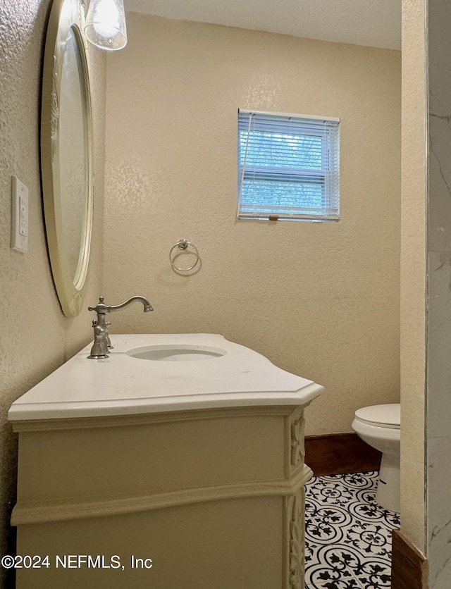 bathroom with tile patterned flooring, toilet, and vanity