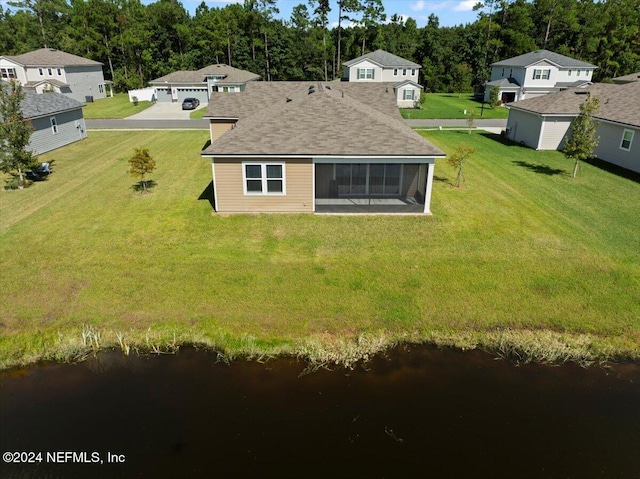 exterior space with a water view, a sunroom, and a yard