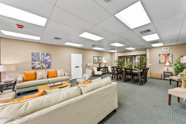 living room with a paneled ceiling and carpet flooring