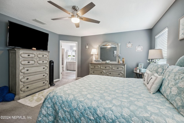 bedroom with connected bathroom, light colored carpet, visible vents, and ceiling fan