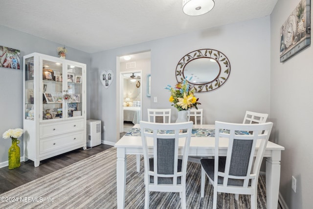 dining room featuring dark wood-type flooring, visible vents, baseboards, and a ceiling fan