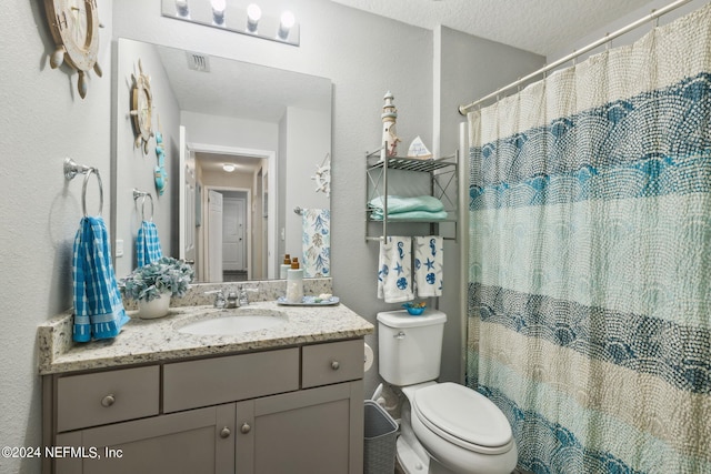 bathroom with a textured ceiling, a textured wall, toilet, a shower with shower curtain, and vanity