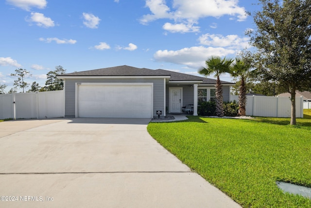 view of front of property featuring a garage, concrete driveway, a gate, fence, and a front yard