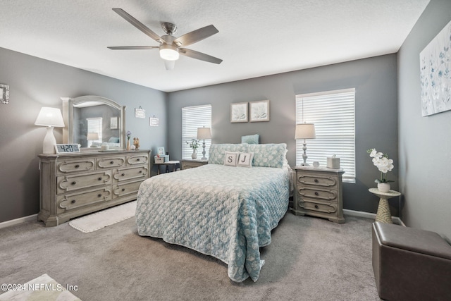 carpeted bedroom with ceiling fan and baseboards